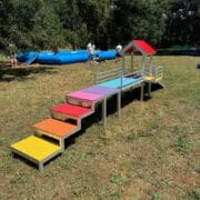 aire-de-jeux-petite-race Aire de jeux petite race vue de l'escalier multicolore menant à la passerelle et à la rampe verte